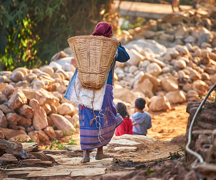 Woman carries basket in Nepal